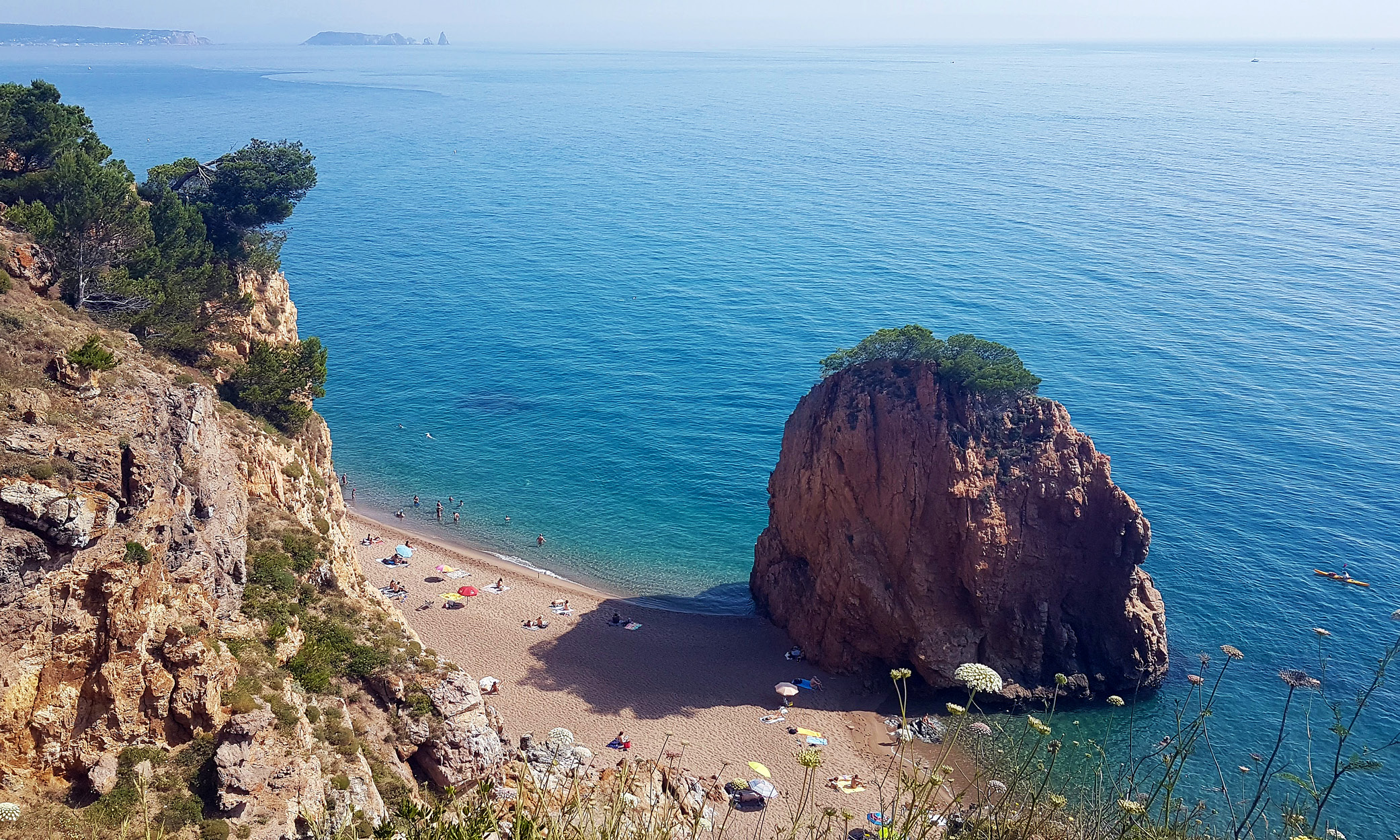 The “Red Island” that gives Platja de l’Illa Roja its name