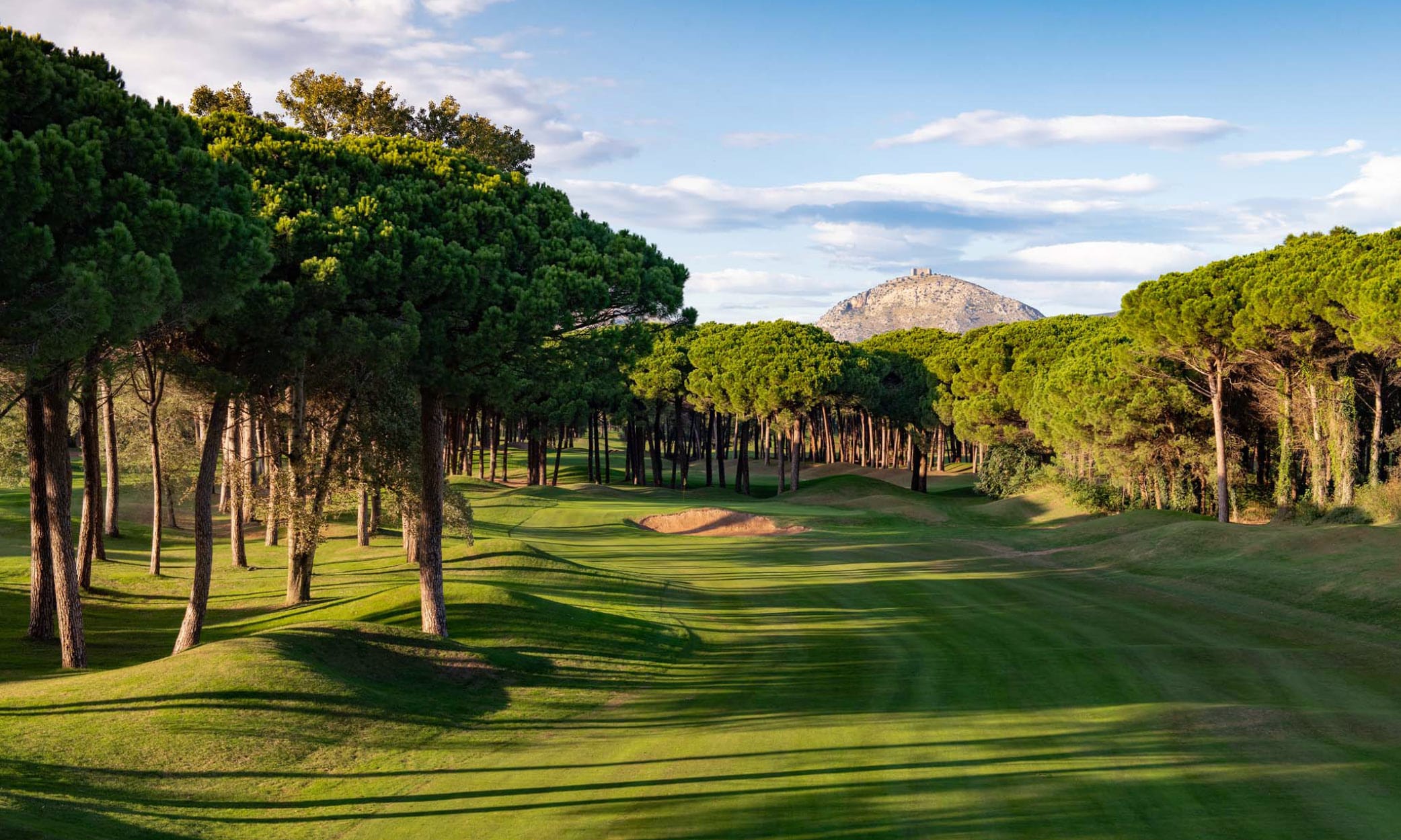 A spectacular fairway on the course at Empordà Golf Club with Montgrí Castle in the distance