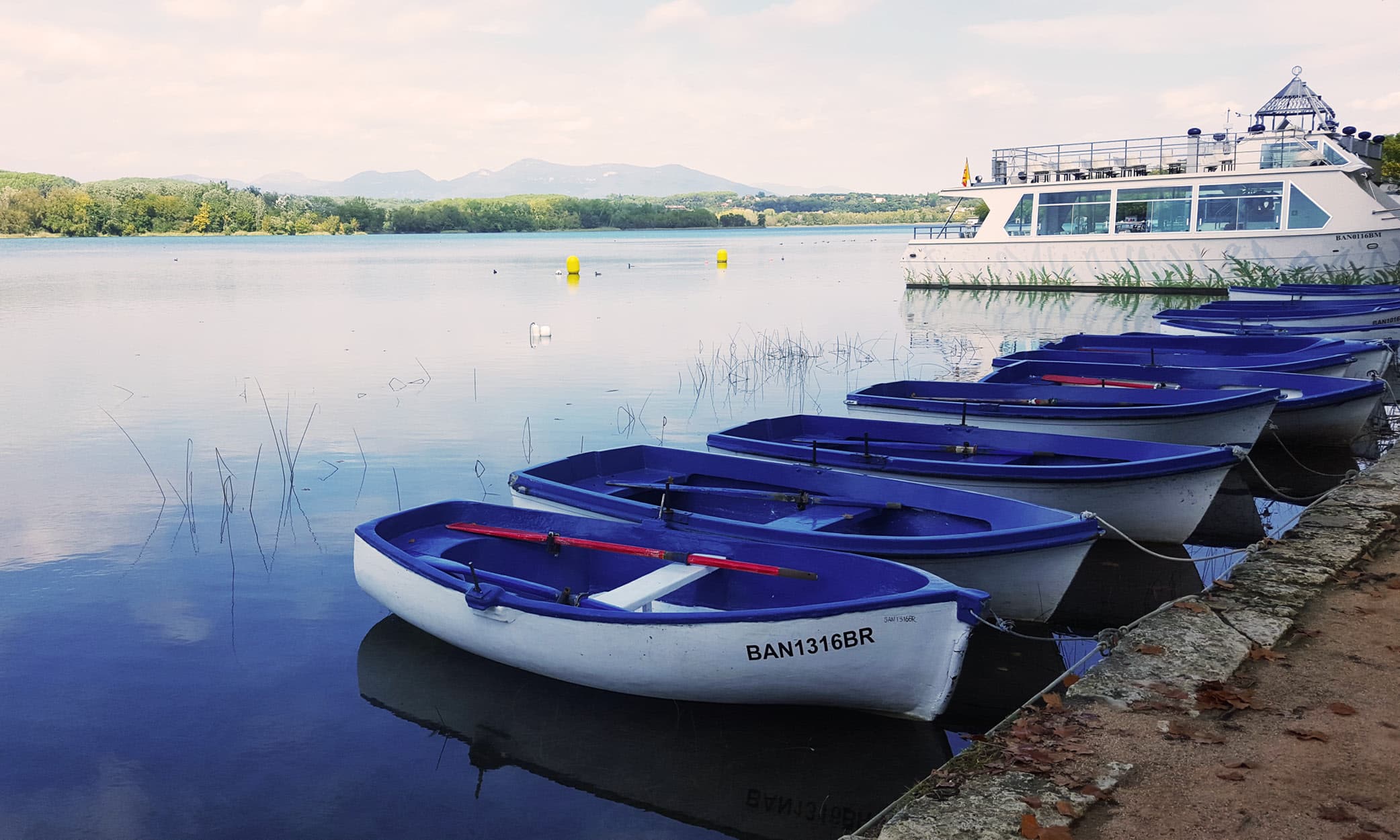 Some leisure craft tied up on the shore of Lake Banyoles