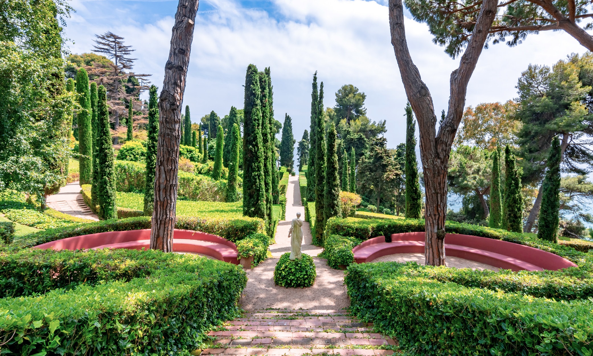 Panoramic view of the Jardines de Santa Clotilde in Lloret de Mar, with lush cypress trees, terraced gardens, and Mediterranean Sea backdrop.